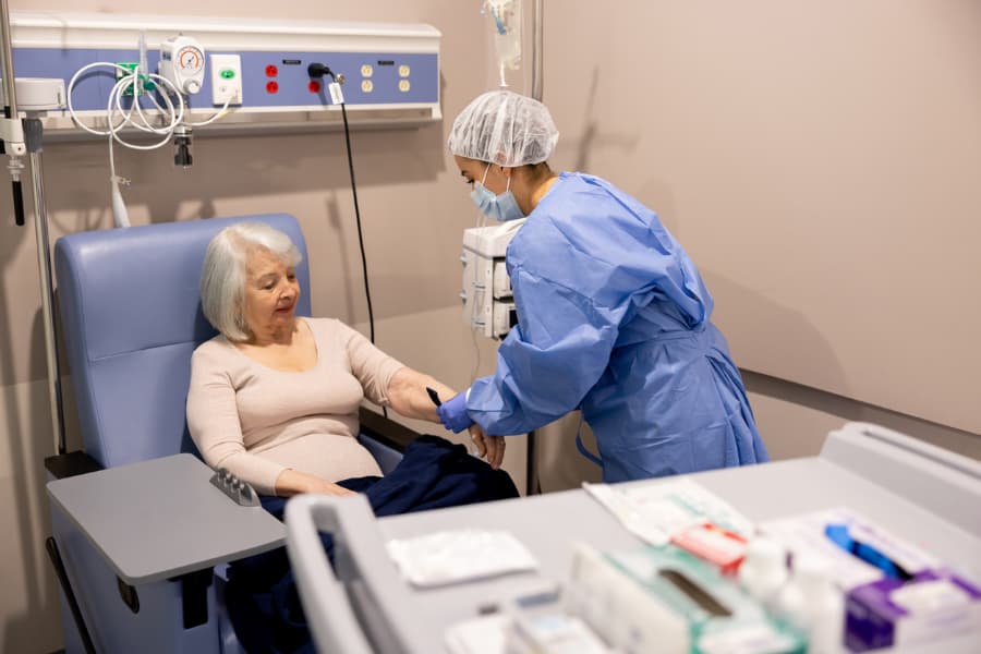 Nurse prepares patient for cancer treatment