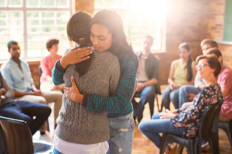 Two people hugging at a grief support group meeting