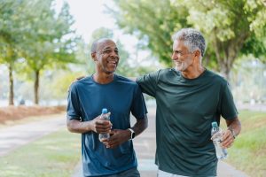 Two active men running in park for exercise to prevent prostate cancer