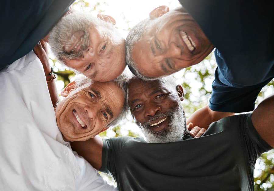 Happy survivors of prostate cancer huddled in circle, supporting each other