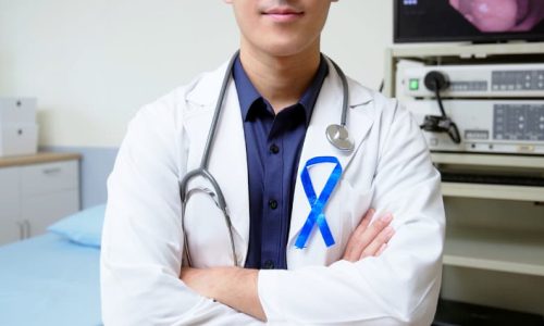 Physician with arms folded wearing white medical coat with blue ribbon