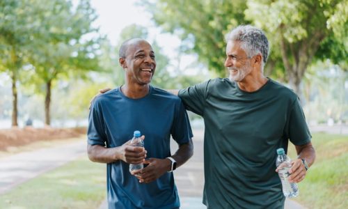 Two active men running in park for exercise to prevent prostate cancer